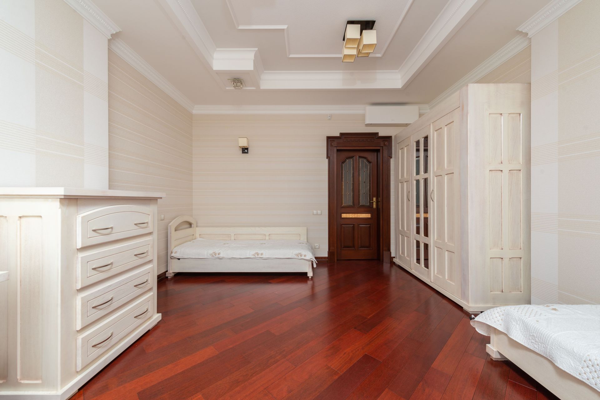 A modern bedroom with wooden flooring, stylish furniture, and elegant decor.